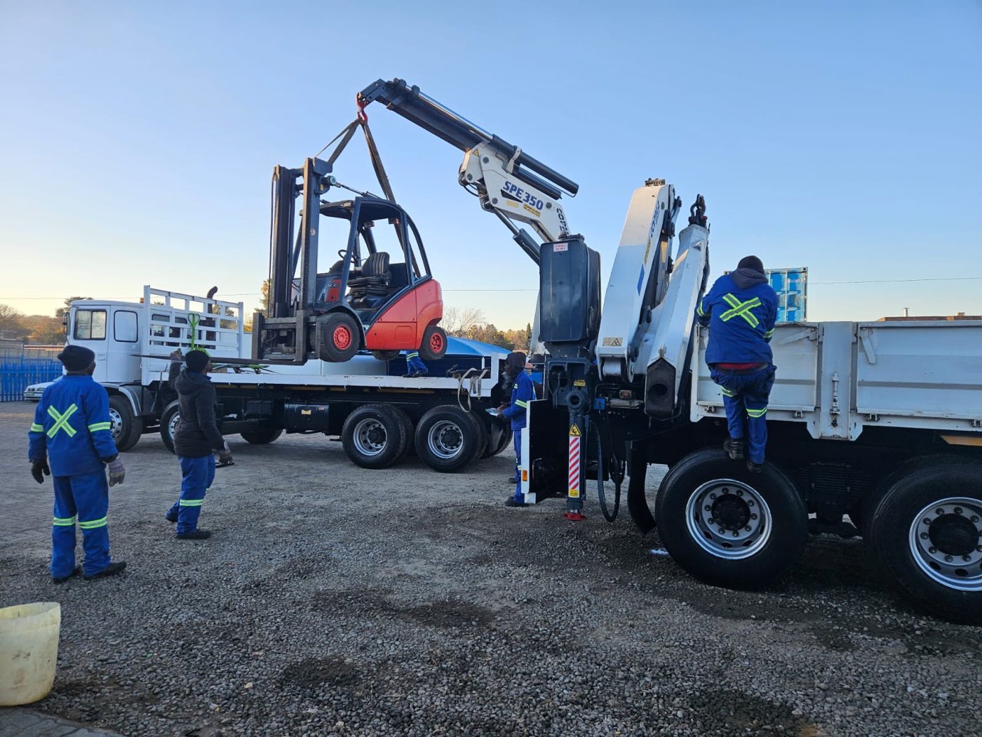 Riggers loading a forklift